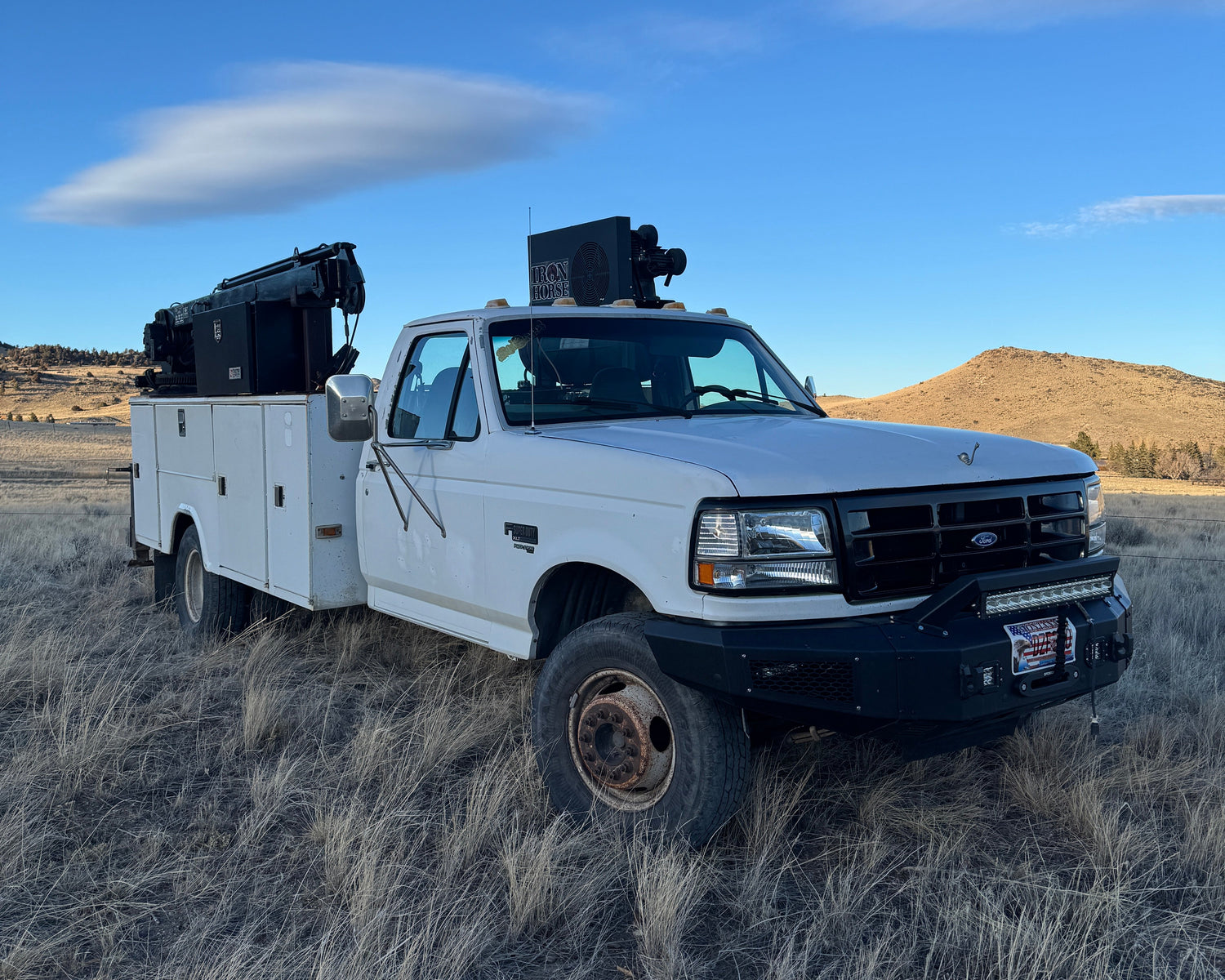 White truck on a dirt road with a clear blue sky